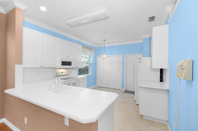 kitchen featuring pendant lighting, white appliances, kitchen peninsula, and white cabinets