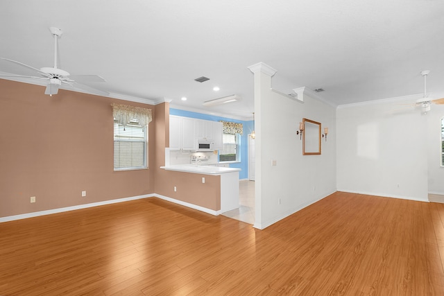 unfurnished living room featuring ornamental molding, light wood-type flooring, and ceiling fan