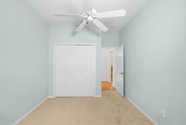 unfurnished bedroom with light colored carpet, a closet, and ceiling fan