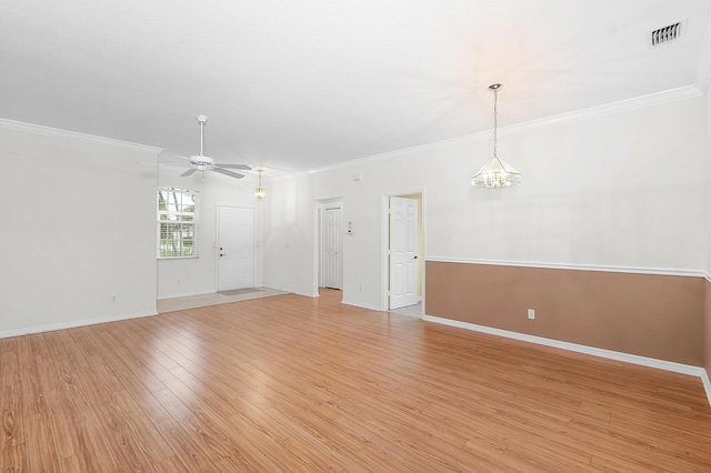 empty room featuring crown molding, light hardwood / wood-style flooring, and ceiling fan with notable chandelier