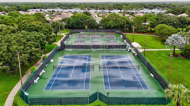 view of tennis court with a yard