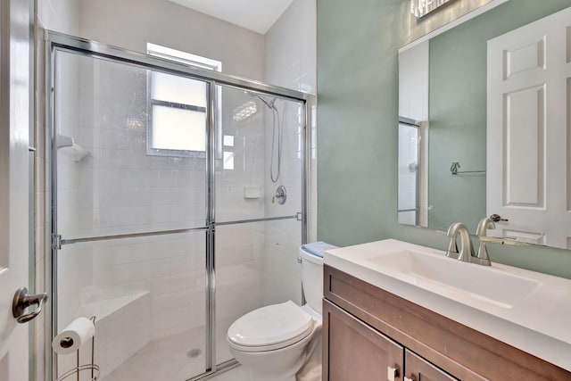 bathroom with vanity, toilet, and a shower with shower door