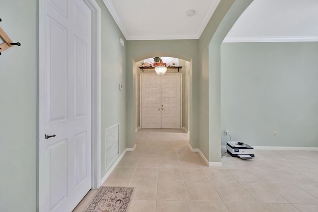 hall with light tile patterned floors and ornamental molding