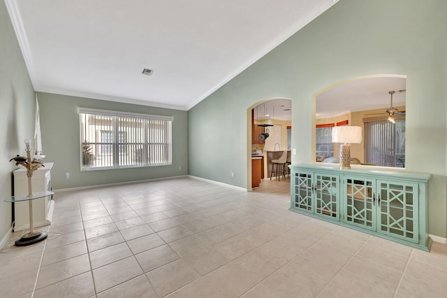 tiled empty room featuring ceiling fan and crown molding