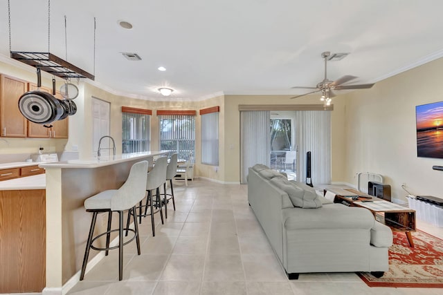 tiled living room with ceiling fan and crown molding