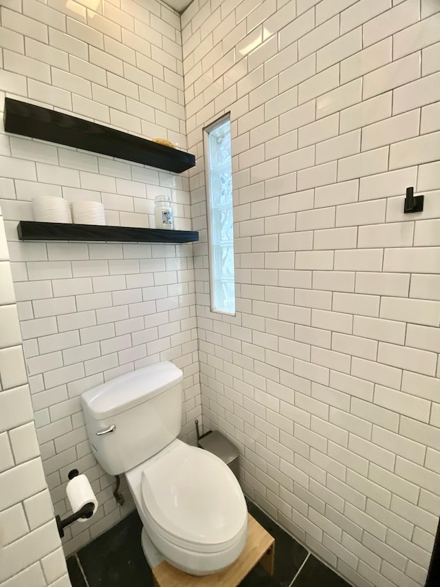 bathroom featuring tile walls and toilet