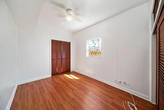 unfurnished bedroom featuring ceiling fan, a closet, and hardwood / wood-style floors