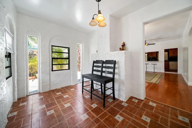 interior space with ceiling fan with notable chandelier and dark hardwood / wood-style floors