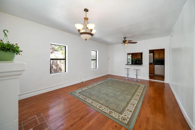 interior space featuring ceiling fan with notable chandelier and dark hardwood / wood-style floors