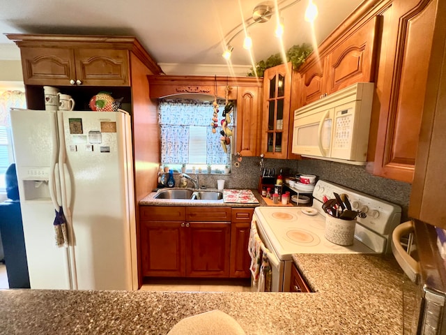 kitchen featuring backsplash, white appliances, light stone countertops, and sink