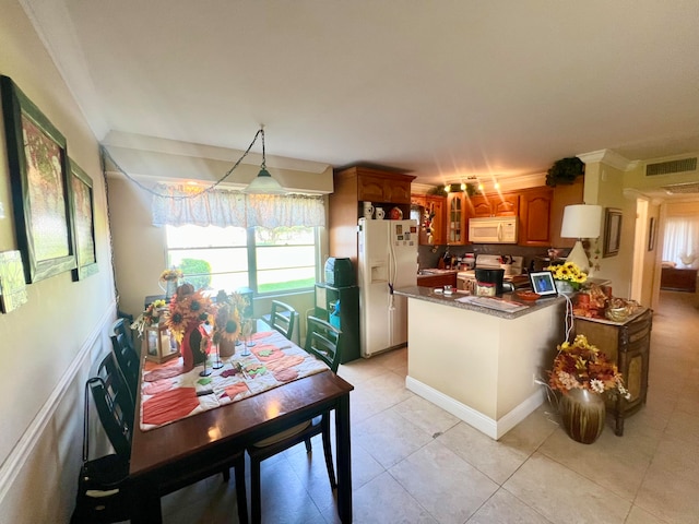 kitchen featuring ornamental molding, white appliances, light tile patterned flooring, and a wealth of natural light