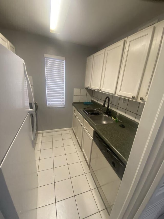 kitchen with white refrigerator, sink, white cabinets, light tile patterned floors, and stainless steel dishwasher