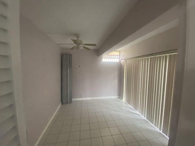 empty room featuring ceiling fan and light tile patterned floors