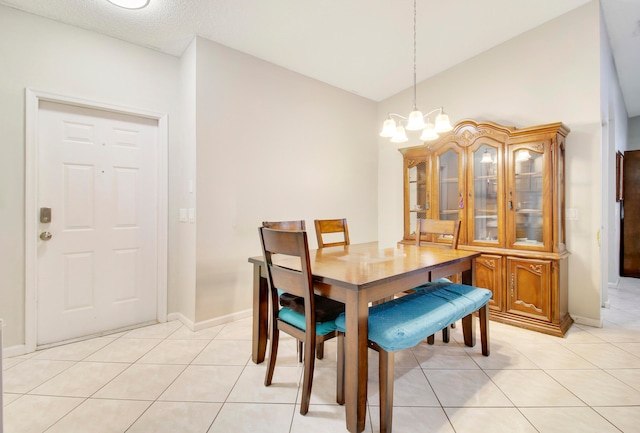 dining room featuring a notable chandelier, vaulted ceiling, a textured ceiling, and light tile patterned flooring