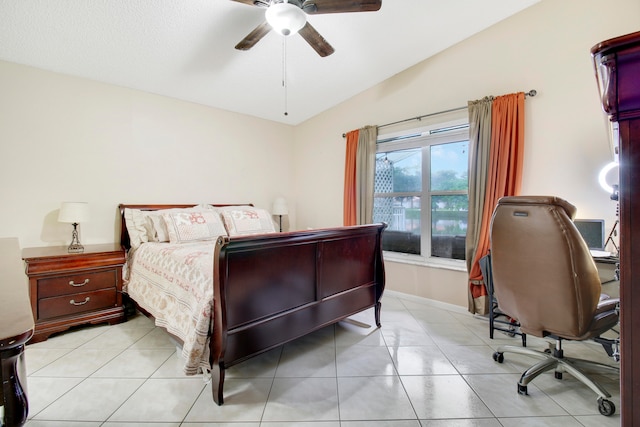 bedroom with ceiling fan, vaulted ceiling, and light tile patterned floors