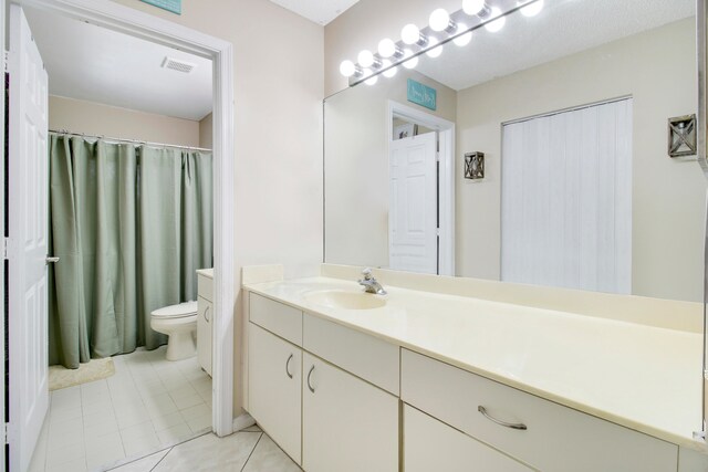 bathroom with vanity, tile patterned flooring, and toilet