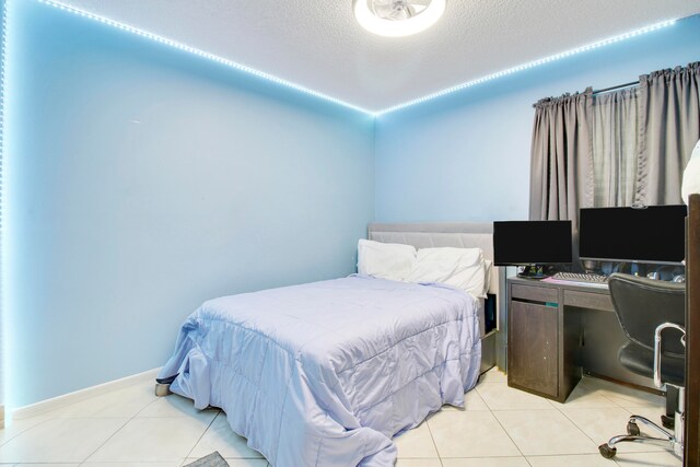 bedroom with light tile patterned floors and a textured ceiling