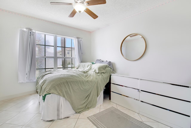 tiled bedroom featuring ceiling fan and a textured ceiling