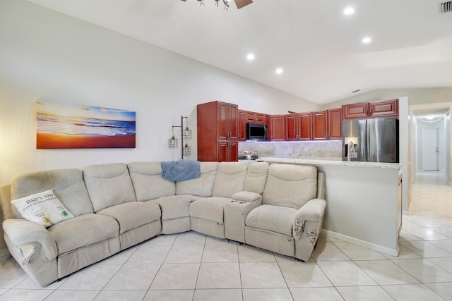 living room with lofted ceiling, ceiling fan, and light tile patterned floors