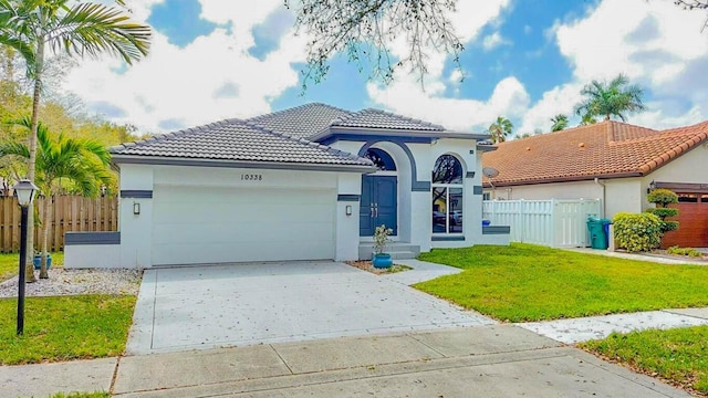 mediterranean / spanish home with a front lawn and a garage