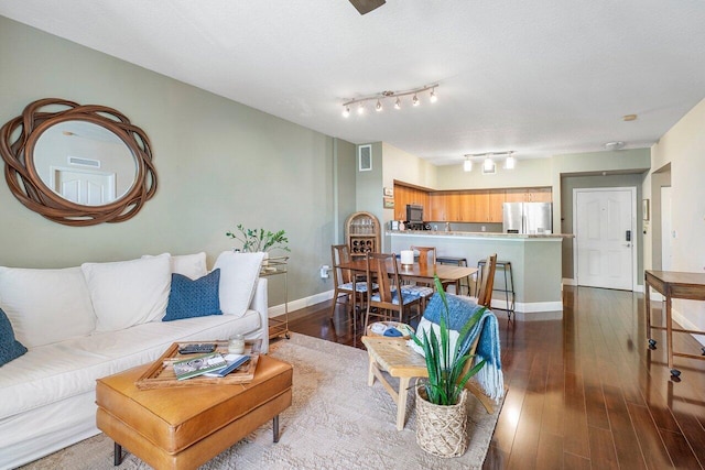 living room featuring hardwood / wood-style flooring, track lighting, and a textured ceiling