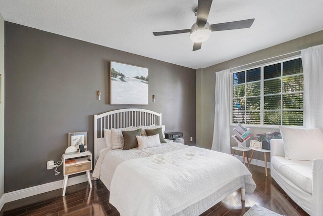 bedroom featuring ceiling fan, dark hardwood / wood-style floors, and a textured ceiling