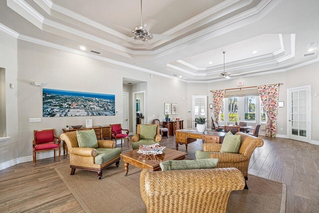 living room with ceiling fan, hardwood / wood-style flooring, a raised ceiling, and crown molding