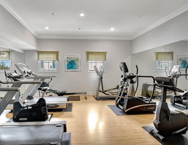 workout area featuring light wood-type flooring and crown molding