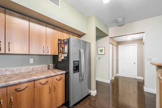 kitchen with a textured ceiling, dark hardwood / wood-style floors, and stainless steel fridge with ice dispenser