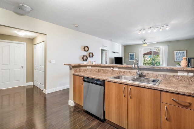 kitchen featuring dark hardwood / wood-style flooring, dishwasher, a textured ceiling, and sink