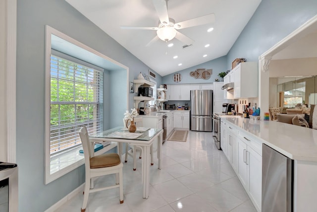 kitchen with a wealth of natural light, white cabinets, ceiling fan, and appliances with stainless steel finishes