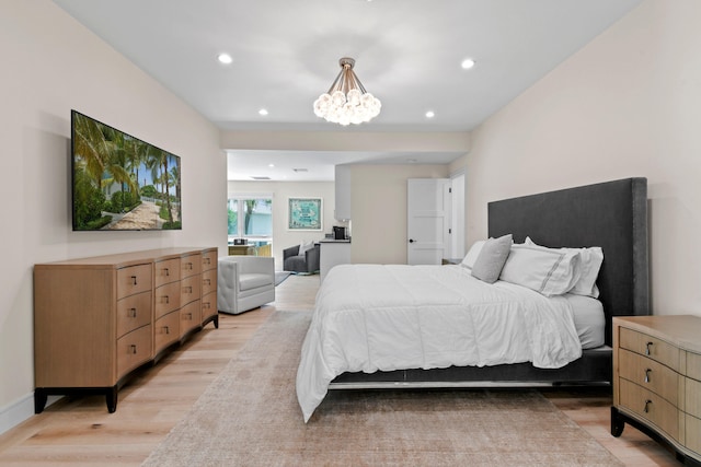 bedroom with an inviting chandelier and light wood-type flooring