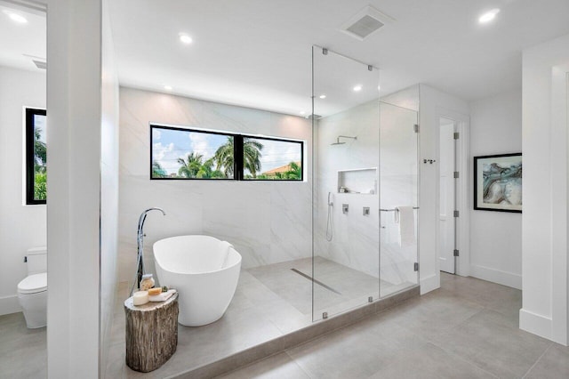 bathroom featuring shower with separate bathtub and toilet