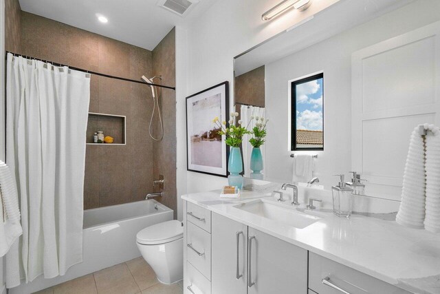 full bathroom with tile patterned floors, shower / bath combo, vanity, and toilet