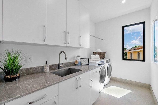 laundry room featuring cabinets, washing machine and dryer, and sink