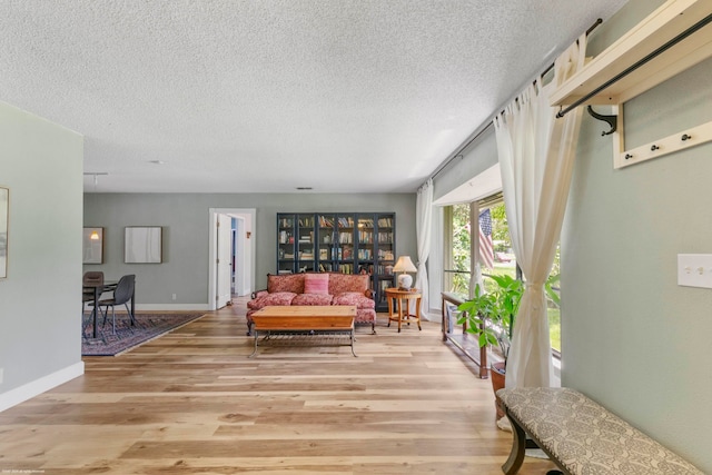 living area featuring light wood-type flooring and a textured ceiling