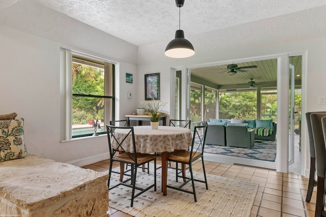 dining room with a textured ceiling, light tile patterned flooring, and ceiling fan