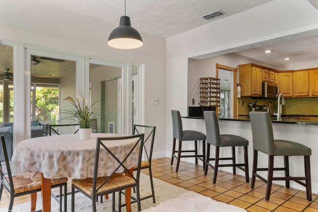 tiled dining room featuring a textured ceiling