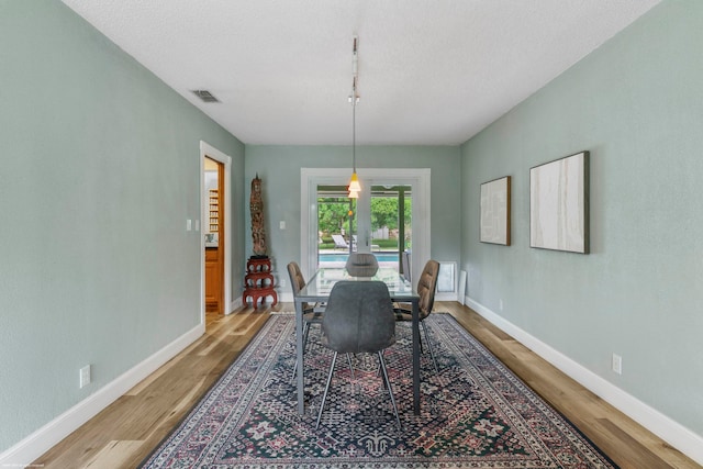 dining area featuring a textured ceiling and hardwood / wood-style flooring