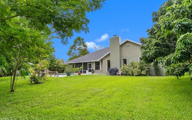 back of house featuring a lawn and a patio area