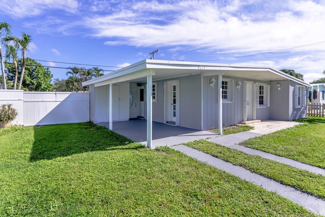 view of front of house featuring a carport and a front lawn