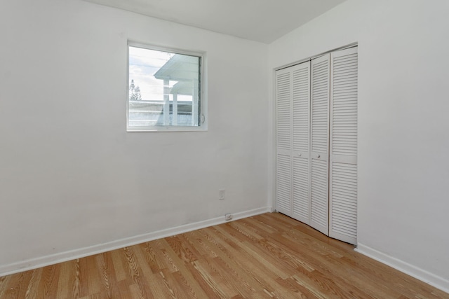 unfurnished bedroom featuring light hardwood / wood-style flooring and a closet