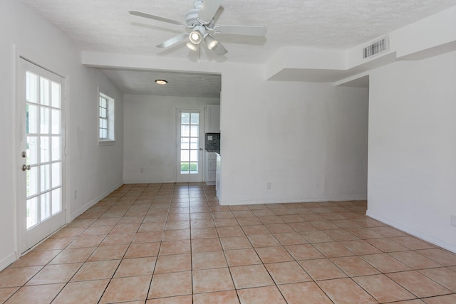 tiled spare room featuring a textured ceiling and ceiling fan