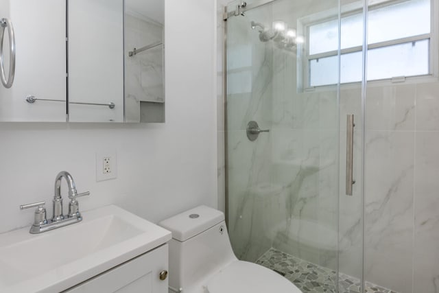 bathroom with walk in shower, vanity, and toilet