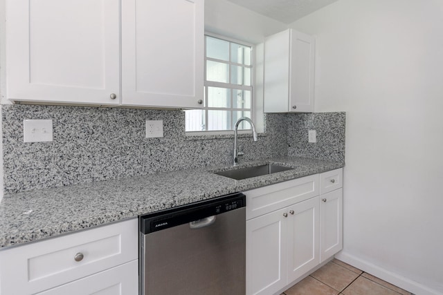 kitchen featuring white cabinets, sink, tasteful backsplash, stainless steel dishwasher, and light stone countertops