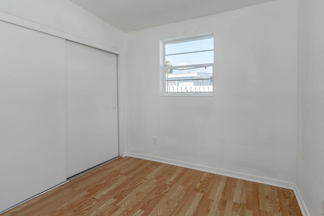 unfurnished bedroom featuring light hardwood / wood-style flooring and a closet