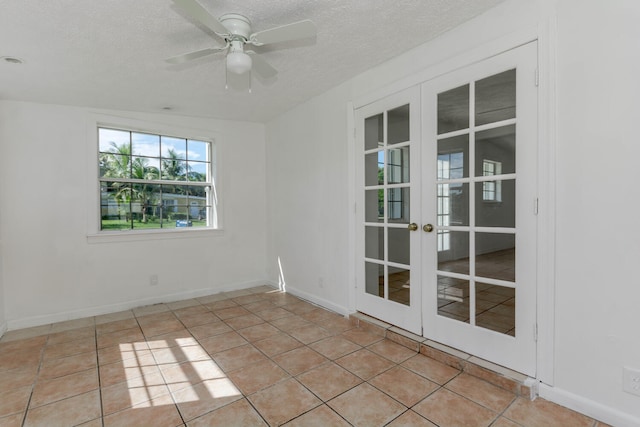 spare room with french doors, a textured ceiling, light tile patterned floors, and ceiling fan