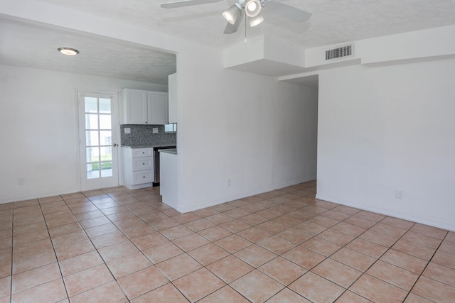 unfurnished room featuring a textured ceiling, ceiling fan, and light tile patterned floors