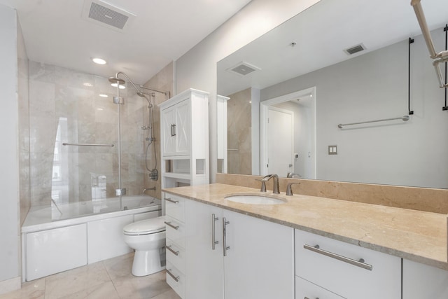 full bathroom featuring tile patterned flooring, tiled shower / bath combo, vanity, and toilet