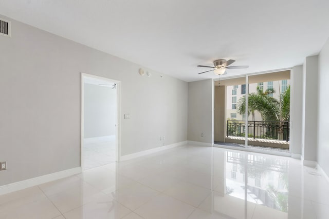 tiled spare room featuring ceiling fan